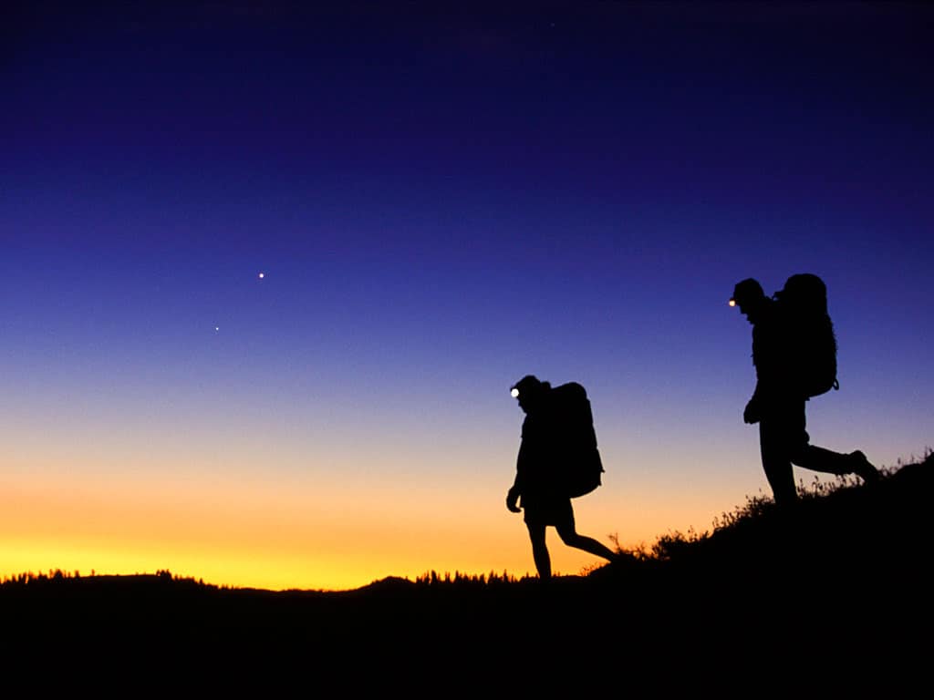 Two hikers at sunrise.